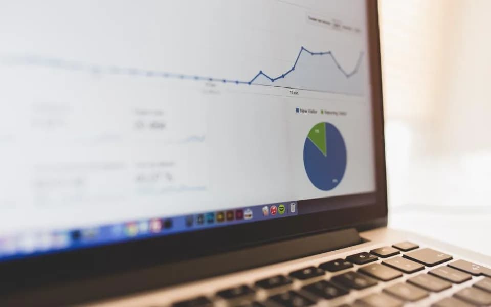 A trend line and pie chart on a laptop screen, close up.